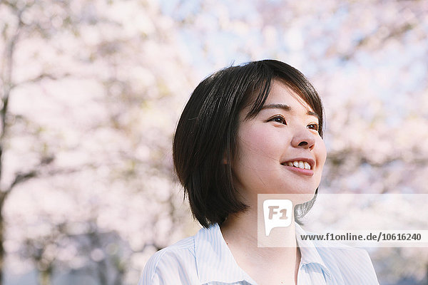 Junge Japanerin erfreut sich an blühenden Kirschblüten in Tokio