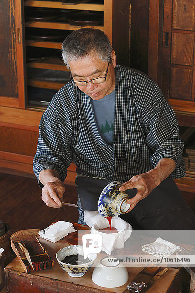 Japanese lacquer artisan working in the studio