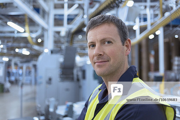 Nahaufnahme des Porträts eines selbstbewussten Arbeiters in der Fabrik