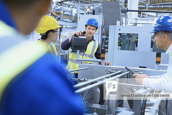 Arbeiter im Gespräch an Maschinen in der Fabrik