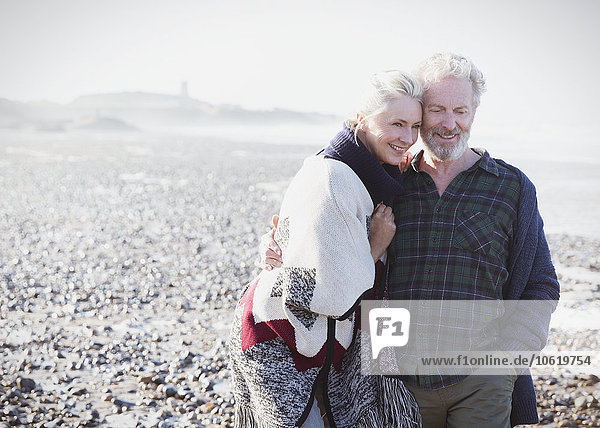 Lächelndes Seniorenpaar beim Spaziergang am Strand