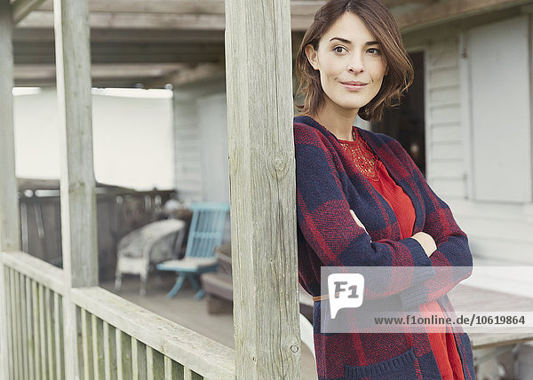 Nachdenkliche Frau im Pullover mit Blick auf die Veranda