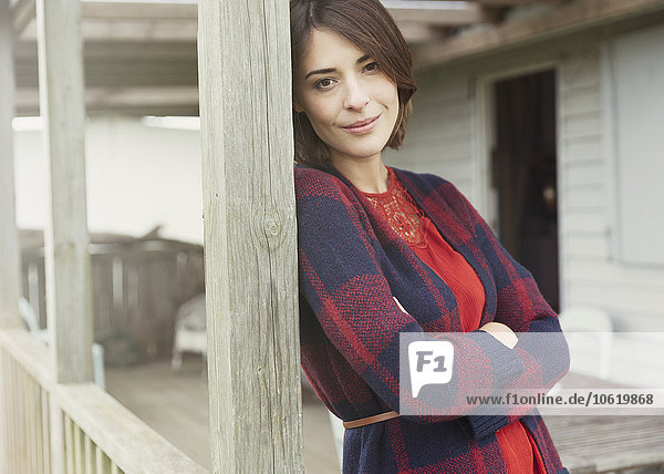 Portrait lächelnde brünette Frau im Pullover auf der Veranda