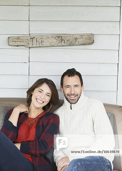 Portrait lächelndes Paar auf der Veranda unter dem Schild The Shack .