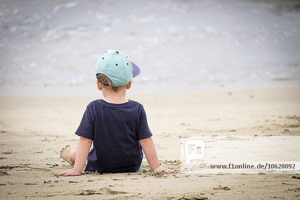 Rückansicht des kleinen Jungen am Strand an der Strandpromenade