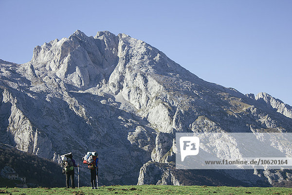 Spain  Picos de Europa  two hikers with mountains landscape in the background