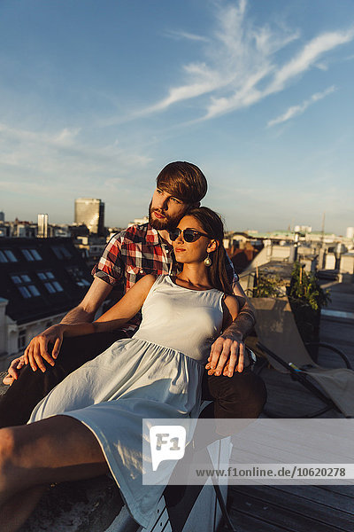 Austria  Vienna  Young couple enjoying romantic sunset on rooftop terrace