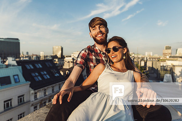 Österreich  Wien  Junges Paar genießt romantischen Sonnenuntergang auf der Dachterrasse