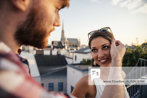 Österreich  Wien  Porträt einer lächelnden jungen Frau von Angesicht zu Angesicht mit ihrem Freund auf einer Dachterrasse