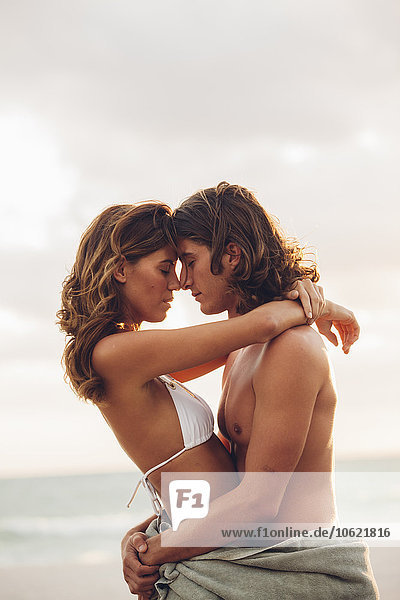 Romantisches  junges Paar  das sich am Strand umarmt.