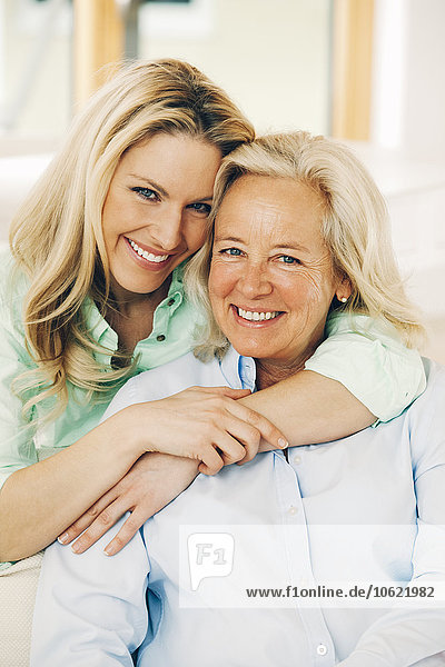 Portrait of smiling adult daughter embracing her mother