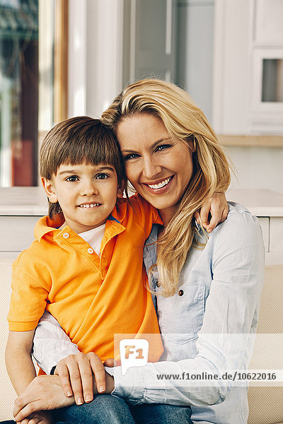 Portrait of smiling mother with son on her lap