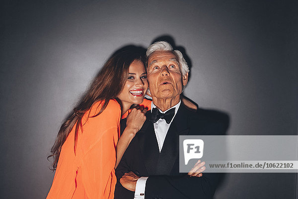 Junge Frau umarmt eleganten älteren Mann