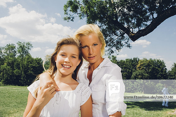 Portrait of mother and daughter together in a park