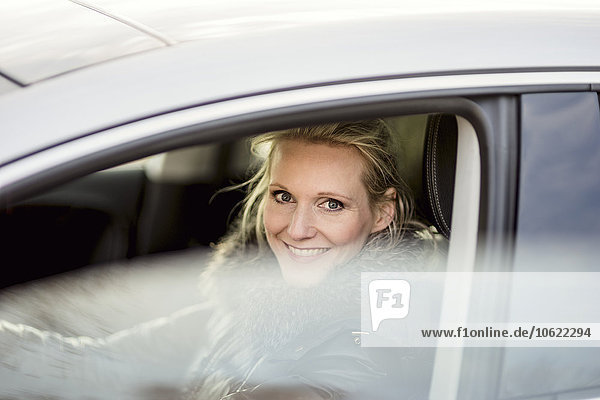 Frau im Auto lächelnd