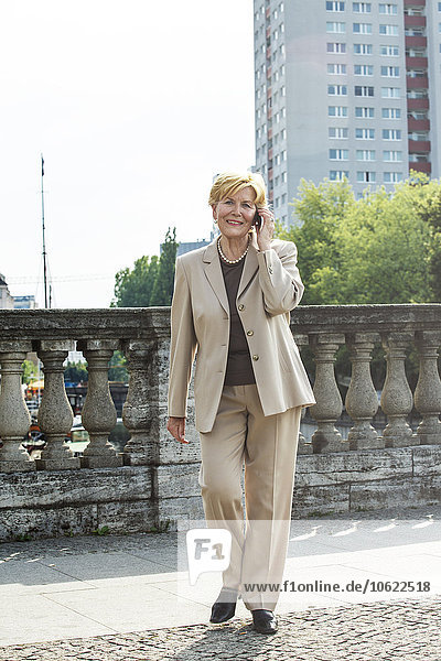 Deutschland  Berlin  Porträt der Senior-Geschäftsfrau beim Telefonieren mit dem Smartphone