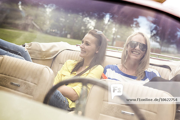 Two happy young women in a convertible