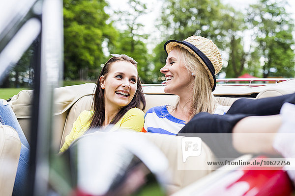 Two happy young women in a convertible