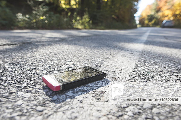 Broken smartphone lying on the road