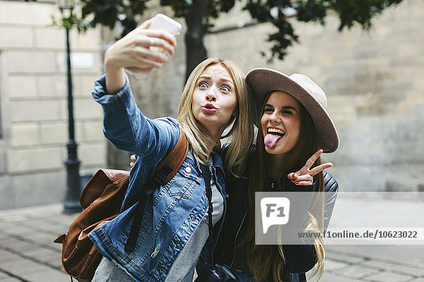Two playful young women taking a selfie