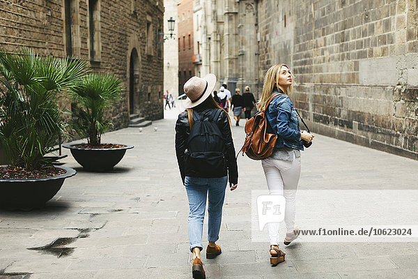 Spain  Barcelona  two young women walking in the city