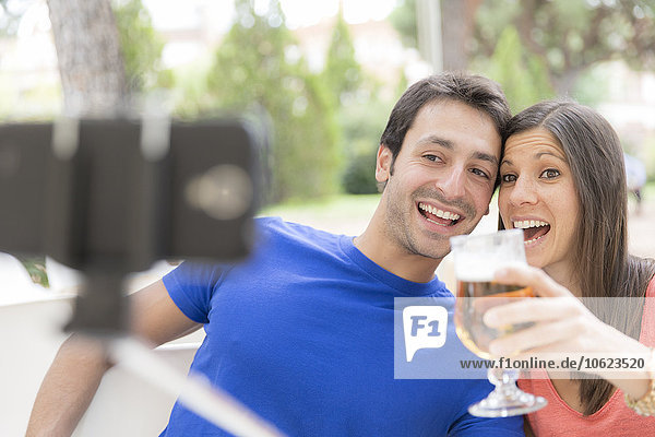 Glückliches Paar mit Selfie-Stick für die Einnahme eines Selfie mit Smartphone