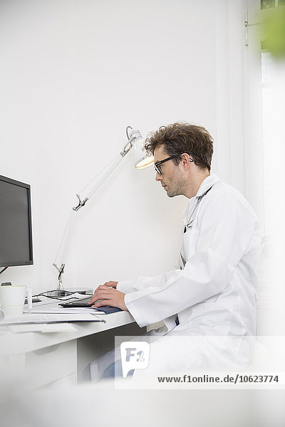 Doctor sitting at desk working on computer