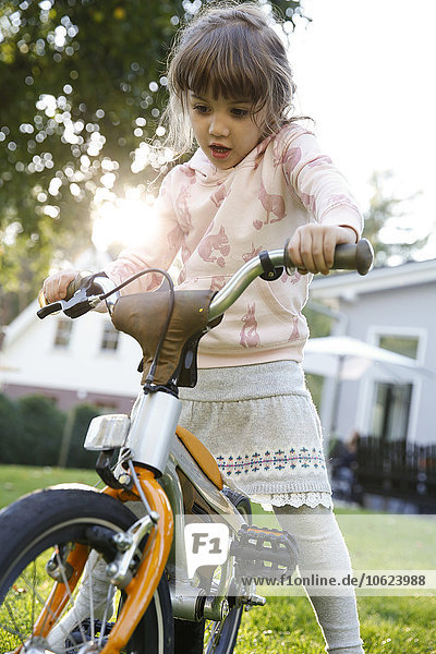 Girl on bicycle in garden