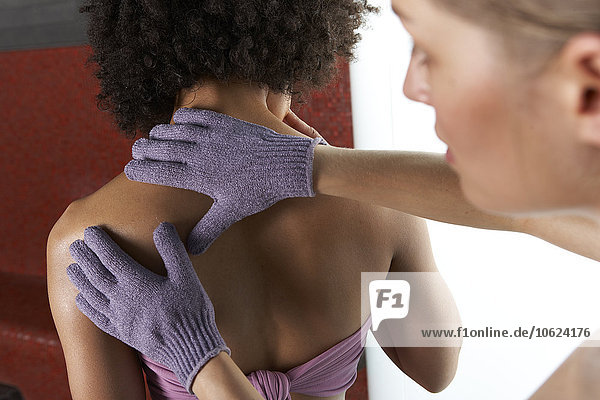 Junge Frau erhält Massage mit Massagehandschuhen  Hamam