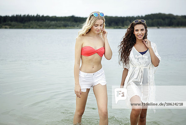 Germany  Haltern  two young women wading through water of Silbersee