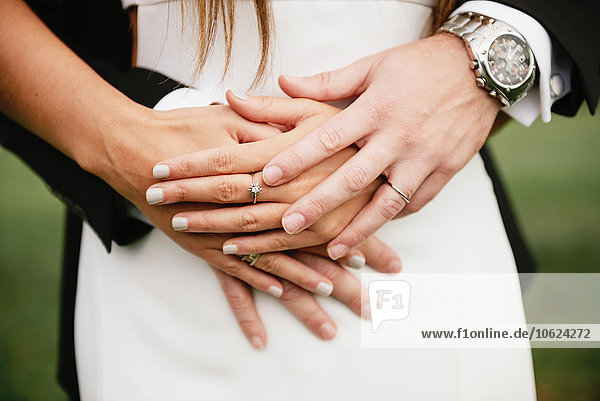 Hände des Brautpaares mit den Eheringen