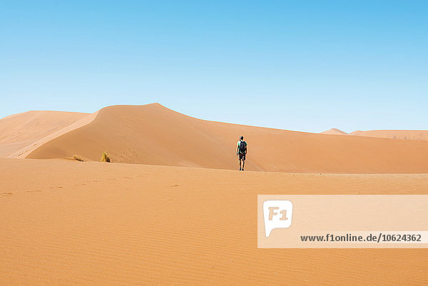Namibia  Namib Desert  Sossusvlei  Man walking through the dunes
