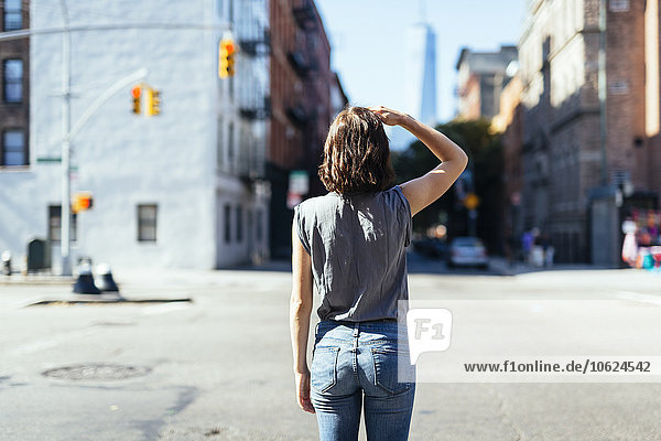 USA  New York City  back view of young woman standing on a street