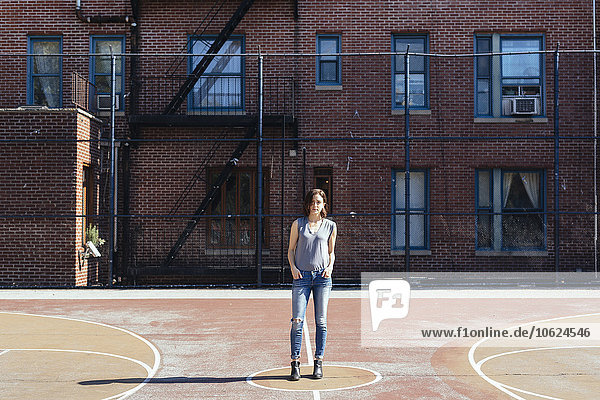 USA  New York City  Manhattan  junge Frau auf einem Spielplatz stehend