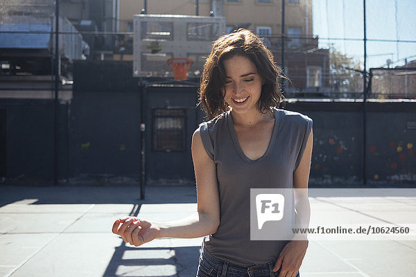 USA  New York  Manhattan  lächelnde junge Frau auf einem Spielplatz