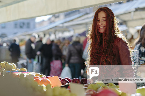 Lächelnde Frau auf dem Obstmarkt