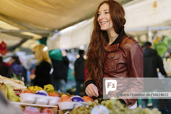 Lächelnde Frau auf dem Obstmarkt