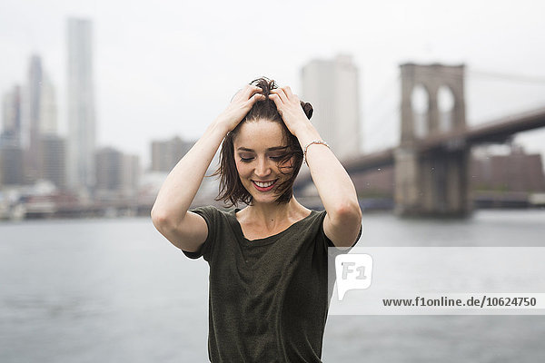 USA  New York City  lächelnde junge Frau auf einem Ausflugsboot an einem windigen Tag