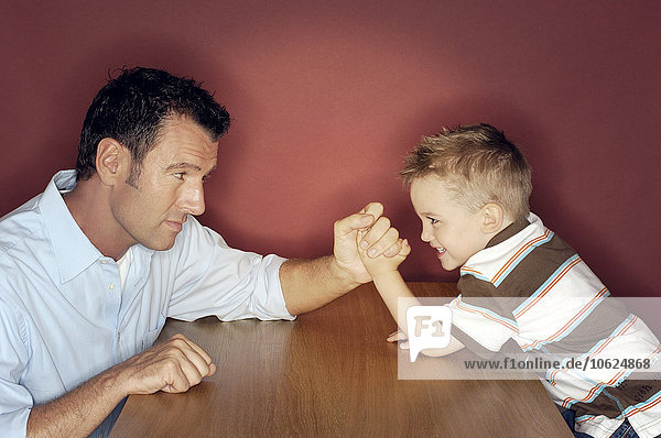 Kleiner Junge im Armdrücken mit seinem Vater