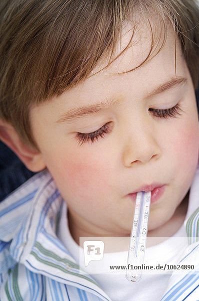 Portrait des kleinen Jungen mit Fieberthermometer im Mund