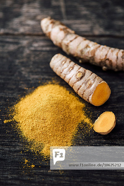 Frisches Curcuma und Pulver auf Holz