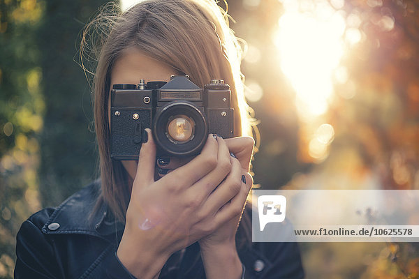 Woman taking photos with vintage camera