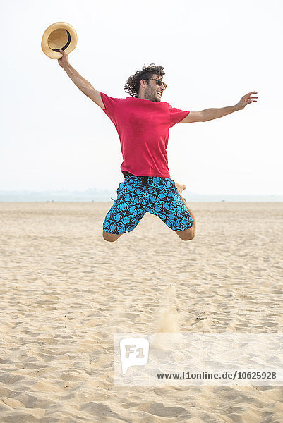 Spanien,  Cadiz,  El Puerto de Santa Maria,  Mann beim Springen am Strand