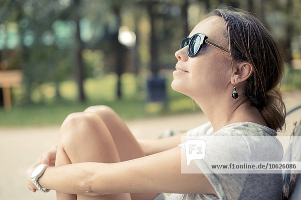 Frau mit Sonnenbrille entspannt im Park