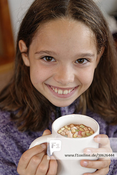 Porträt eines glücklichen Mädchens mit einer Tasse heißer Schokolade mit Marshmallows