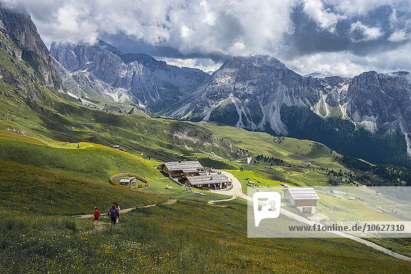 Italy  Dolomites  Odle mountain range  Hikers heading to a chalet