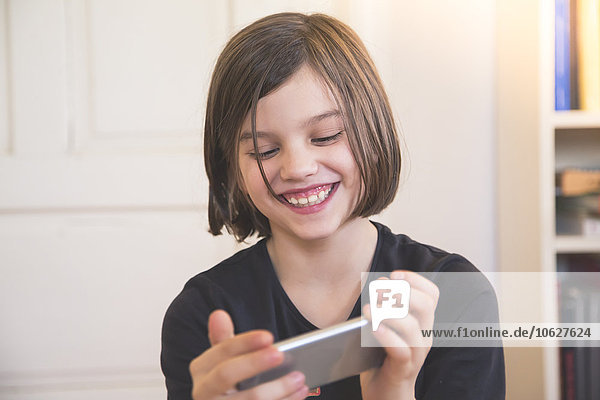 Portrait of smiling girl looking at smartphone