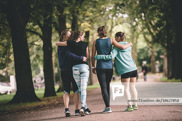 Four female joggers in park