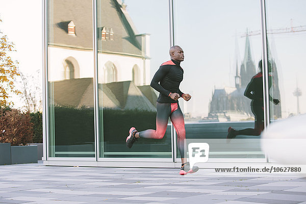 Deutschland  Köln  Sportler an der Glasfront eines Gebäudes mit Spiegelung des Kölner Doms