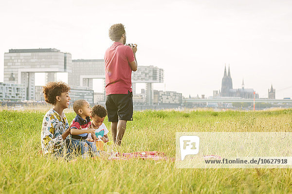Germany  Cologne  family of four resting with blanket in a field